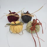 crochet pumpkins in a variety of fall colors with raffia and a cinnamon stick stem, fall table decorations, Thanksgiving decorations