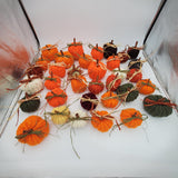 crochet pumpkins in a variety of fall colors with raffia and a cinnamon stick stem, fall table decorations, Thanksgiving decorations